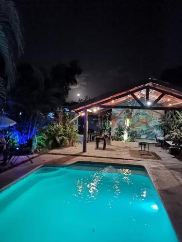 a swimming pool at night with a tent and a table at The Blue House Panama in Chame