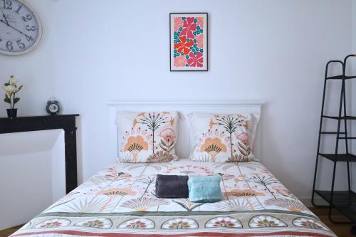 - un lit avec deux oreillers et une photo sur le mur dans l'établissement Le Halo Secret, 40min de Disney, 5 min du centre Coulommiers, à Coulommiers