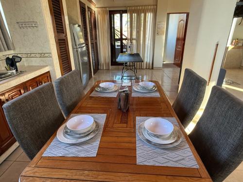 a dining room table with chairs and a wooden table with plates at Departamento paraíso in Lo de Marcos
