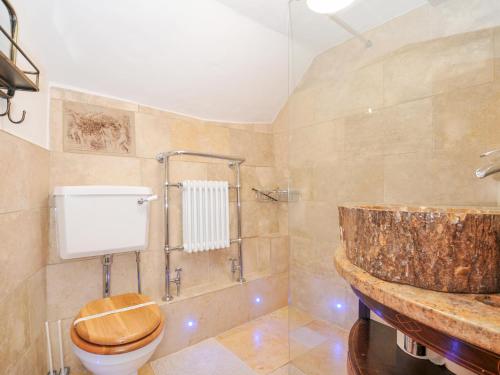 ein Badezimmer mit einem WC aus Holz und einem Waschbecken in der Unterkunft Rose Cottage in Okehampton