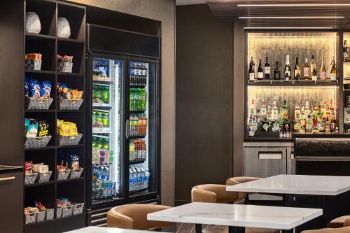 a restaurant with tables and a refrigerator with drinks at Hyatt Place Charlotte Downtown in Charlotte