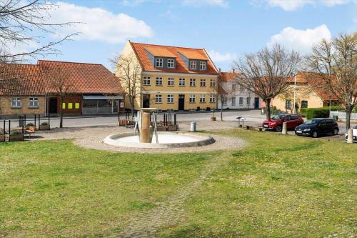 a park in front of a large yellow building at N004-Nysted-Gammel-Torv-4-A-2-tv in Nysted