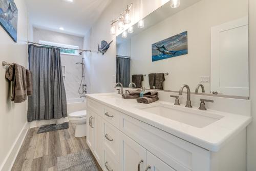 a white bathroom with a sink and a toilet at Walk to Beach Southern Shores Retreat with Hot Tub in Kitty Hawk