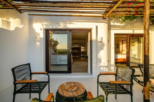 a patio with chairs and a wooden table and a window at Enjoy Jeri Praia in Jericoacoara