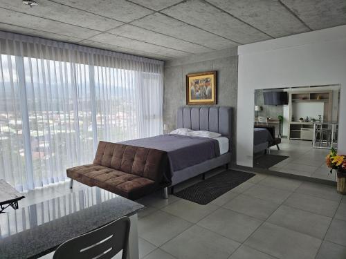a bedroom with a bed and a couch at Urban Breeze iFreses, 10th floor! AC, TV and Pool in Guayabos