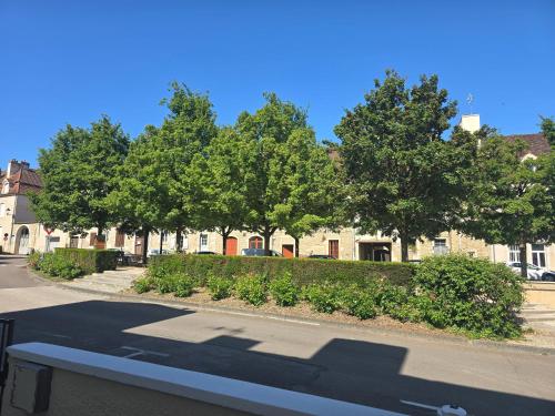 a bench in front of a building with trees at Au cœur du vieux village in Chenôve