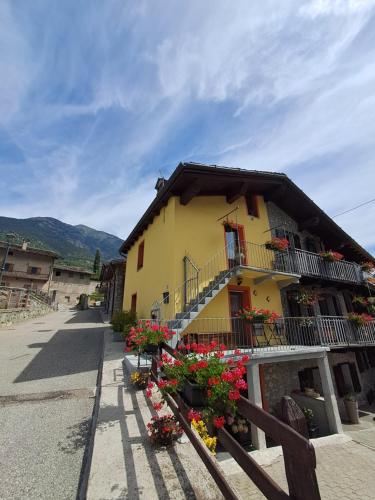 a yellow building with flowers in front of it at La meison de Ciamy in Aosta