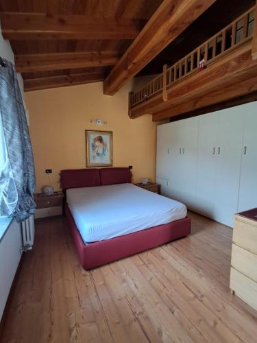 a bedroom with a large bed and a wooden floor at La meison de Ciamy in Aosta