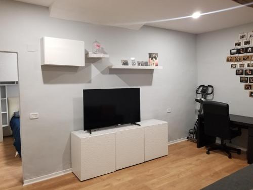 a living room with a flat screen tv on a white wall at Home on Via degli Dei, Close to Florence in Osteria di Novoli