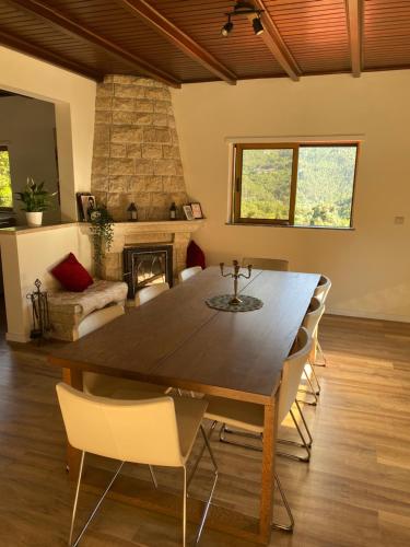 a dining room with a table and a fireplace at Mirante Canto Das Águas Hidden Nature Escape near Geres in Lordelo