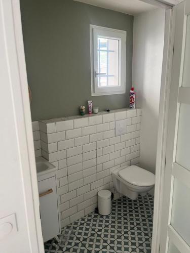 a bathroom with a toilet and a window at Emmanuel INN 3 in Drancy