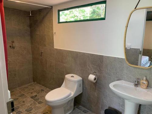 a bathroom with a toilet and a sink at Calalas Lodge in Nindirí