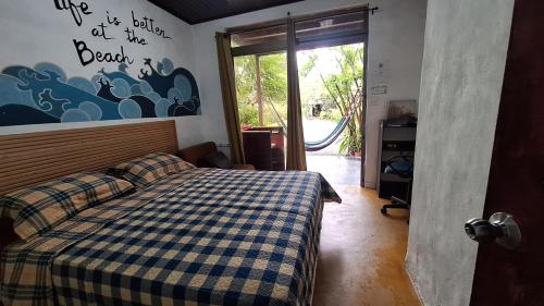 a bedroom with a bed with a blue and white checkered blanket at The Blue House Panama in Chame