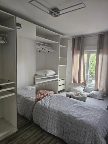 a bedroom with a bed and shelves and a window at Emmanuel INN 3 in Drancy