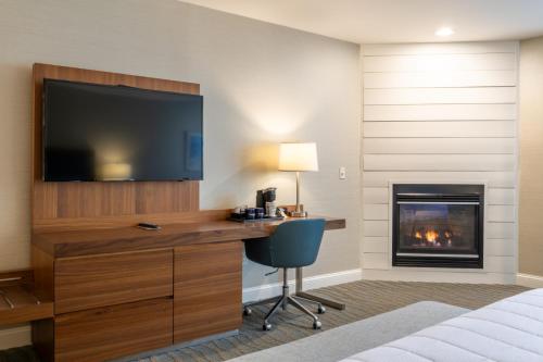 une chambre d'hôtel avec un bureau, une télévision et une cheminée dans l'établissement Anchorage by the Sea, à Ogunquit