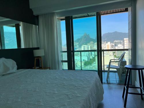 Un dormitorio con una cama y un balcón con vistas. en TIFFANYs RIO FLAT, en Río de Janeiro