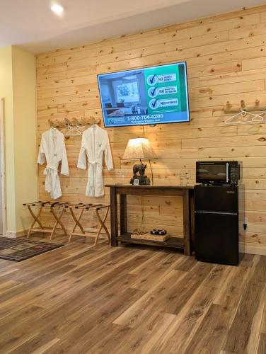 a room with wooden walls and a tv and clothes hanging on a wall at Leech Lake Resort Bed & Breakfast in Walker