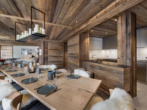 une salle à manger avec des murs en bois et une longue table dans l'établissement Duplex spacieux pour 14 pers. avec sauna, terrasse et parking, au pied des pistes - Méribel Village - FR-1-566-11, à Les Allues