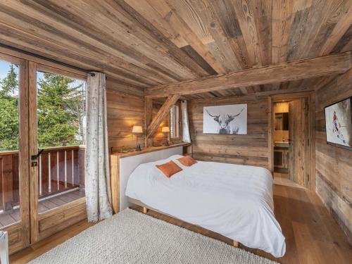 Un dormitorio con una cama en una cabaña de madera. en Chalet 5⭐ à Méribel avec Spa, Salle de Sport, Proche des Pistes et Commerces - FR-1-566-62, en Les Allues