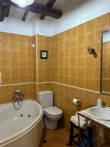 a bathroom with a tub and a toilet and a sink at Casa Rural La Calera in San Millán de la Cogolla
