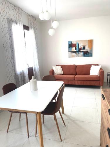 - un salon avec une table blanche et un canapé rouge dans l'établissement Domus, à Teulada