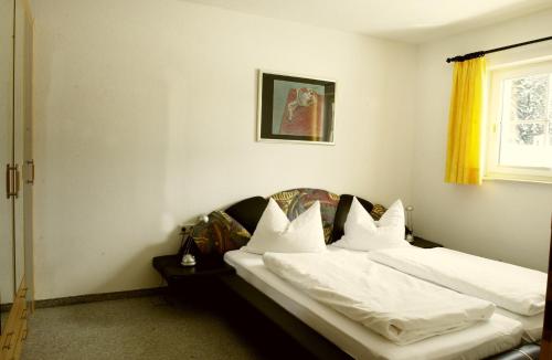a bedroom with two beds with white sheets and a window at Landhaus am Golfplatz in Seefeld in Tirol