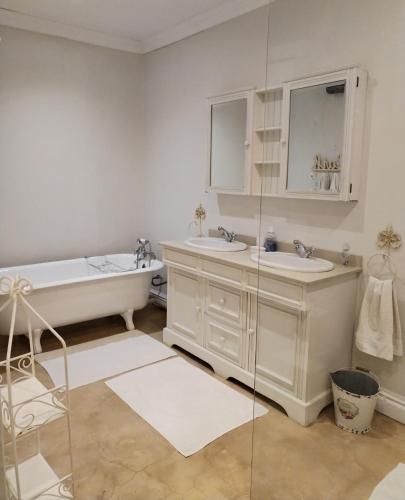 a bathroom with two sinks and a bath tub and a tub at Aviemore Farmhouse in Nottingham Road