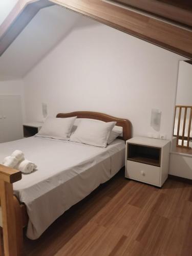a bedroom with a bed and a tv on a wooden floor at La Casa di Levante in Zakynthos