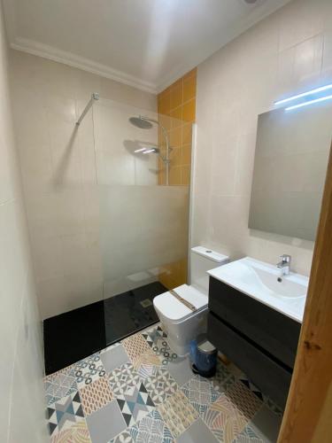 a bathroom with a sink and a toilet and a mirror at SwordFish Charming Retreat in Peniche