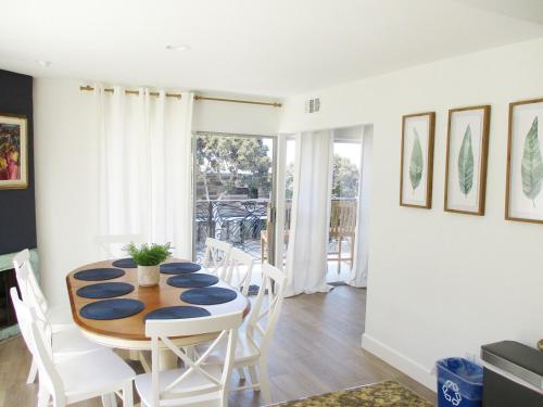a dining room with a table and white chairs at Saint Ann's Court in Laguna Beach