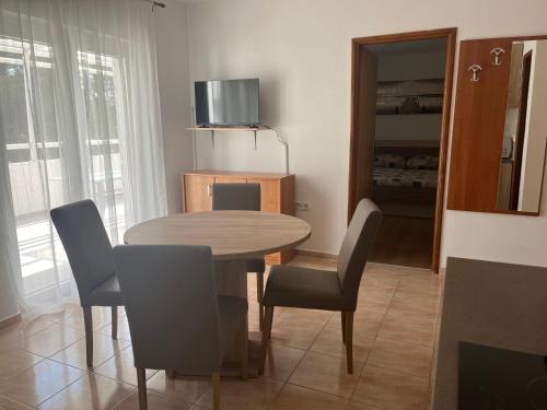 une salle à manger avec une table et des chaises en bois dans l'établissement Apartment Niva, à Nin