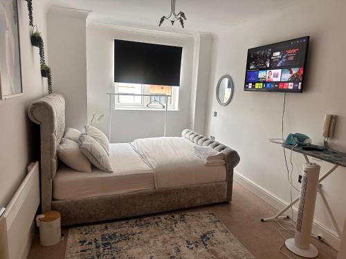 a bedroom with a bed with a television on the wall at Enjoy city living in this one-bedroom flat, complete with a balcony and secure parking in Birmingham city center in Birmingham