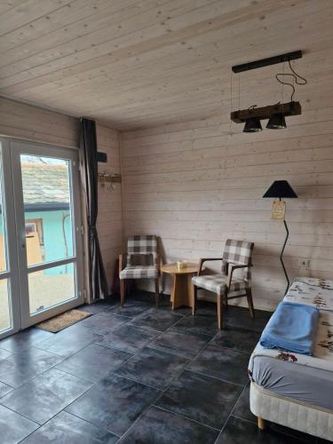 a bedroom with a bed and a table and chairs at Къщички Синьо лято, Черноморец - Варна - Blue Summer Houses Varna in Varna City