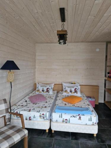 a bedroom with two beds and a lamp and a chair at Къщички Синьо лято, Черноморец - Варна - Blue Summer Houses Varna in Varna City