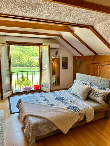 a bedroom with a large bed and a large window at Studio Palma in Zvornik