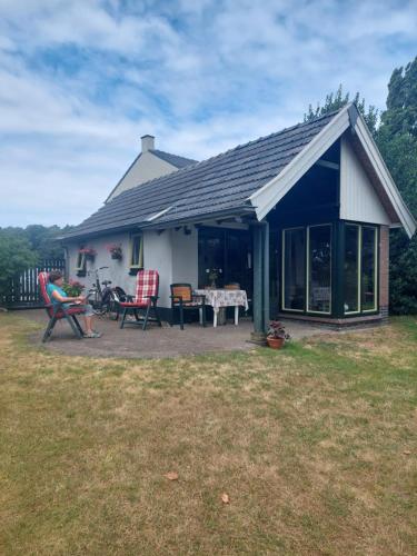 a house with a patio with chairs and a table at Quo Vadis vakantiehuis Lengel in Lengel