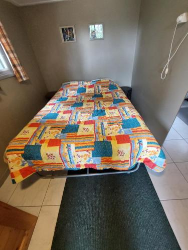 a bed with a colorful comforter in a bedroom at Quo Vadis vakantiehuis Lengel in Lengel