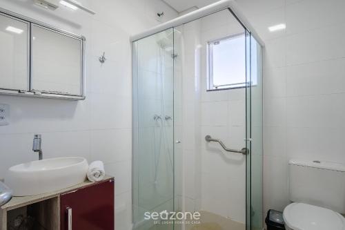 a bathroom with a glass shower and a sink at Apto 2 Quartos a 260m da Praia RIB0201 in Barra de Ibiraquera