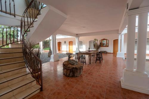 a living room with a staircase and a table with chairs at Casa Ambito in San Raymundo Jalpan
