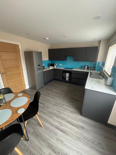 a large kitchen with a table and a table and chairs at 25 Colliers Road,Stirling 