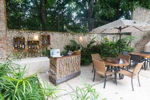 a patio with a table and chairs and an umbrella at Hotel Posada San Juan in Valladolid