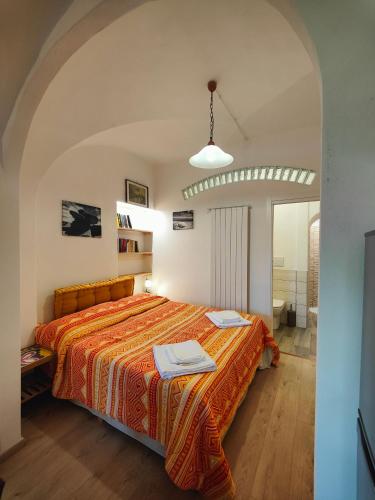 a bedroom with a bed with a orange bedspread at Colline Toscane in Volterra