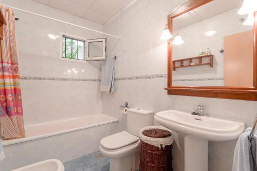 Un baño con un inodoro blanco y un lavabo. en Villa Gallardo, en Campillos