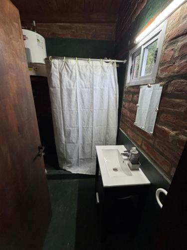 a bathroom with a sink and a white shower curtain at OKIN 1 Cobos in Mar de Cobo
