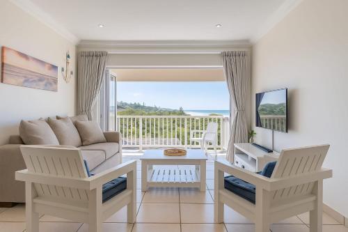 a living room with a couch and a table at Hello Holiday at 4 Boboyi Mangrove Beach Estate in Port Shepstone