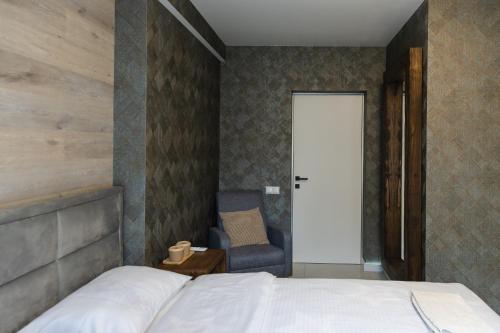 a bedroom with a bed and a chair and a door at 77/5 in Chişinău