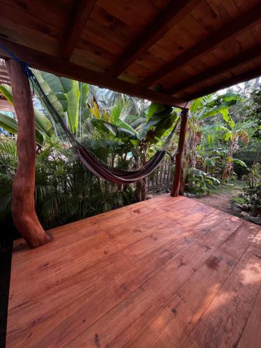 a wooden porch with a hammock on top of it at Apartment Lodge Tres Palmas. Apartment #1 in Temalhuacán