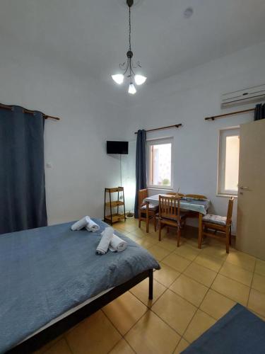 a bedroom with a bed and a table and chairs at Pine Apartments in Ermoupoli