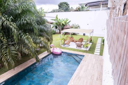 アビジャンにあるGoya Resorts & SPAのガゼボとピンクのフラミンゴのあるプール