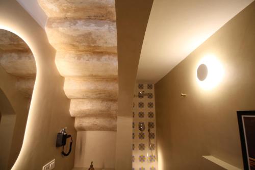 a hallway with a stone wall and a ceiling with beams at Casa Di Benedetta in Gallipoli